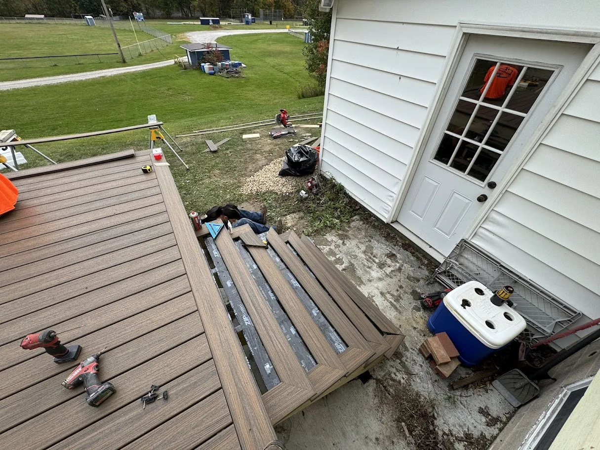 Composite deck boards being installed on pressure-treated frame by Nailed It 440
