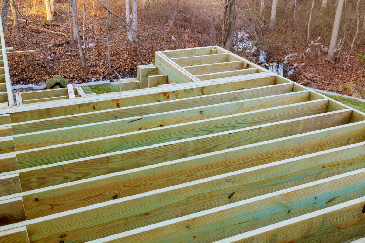 Deck joists and structural framing during construction. these decisions lock in your budget