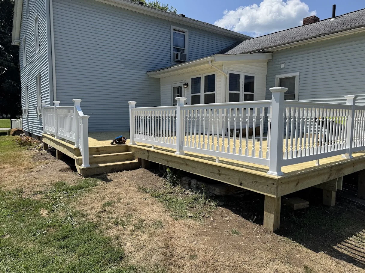 Completed deck featuring white vinyl railings and composite decking material