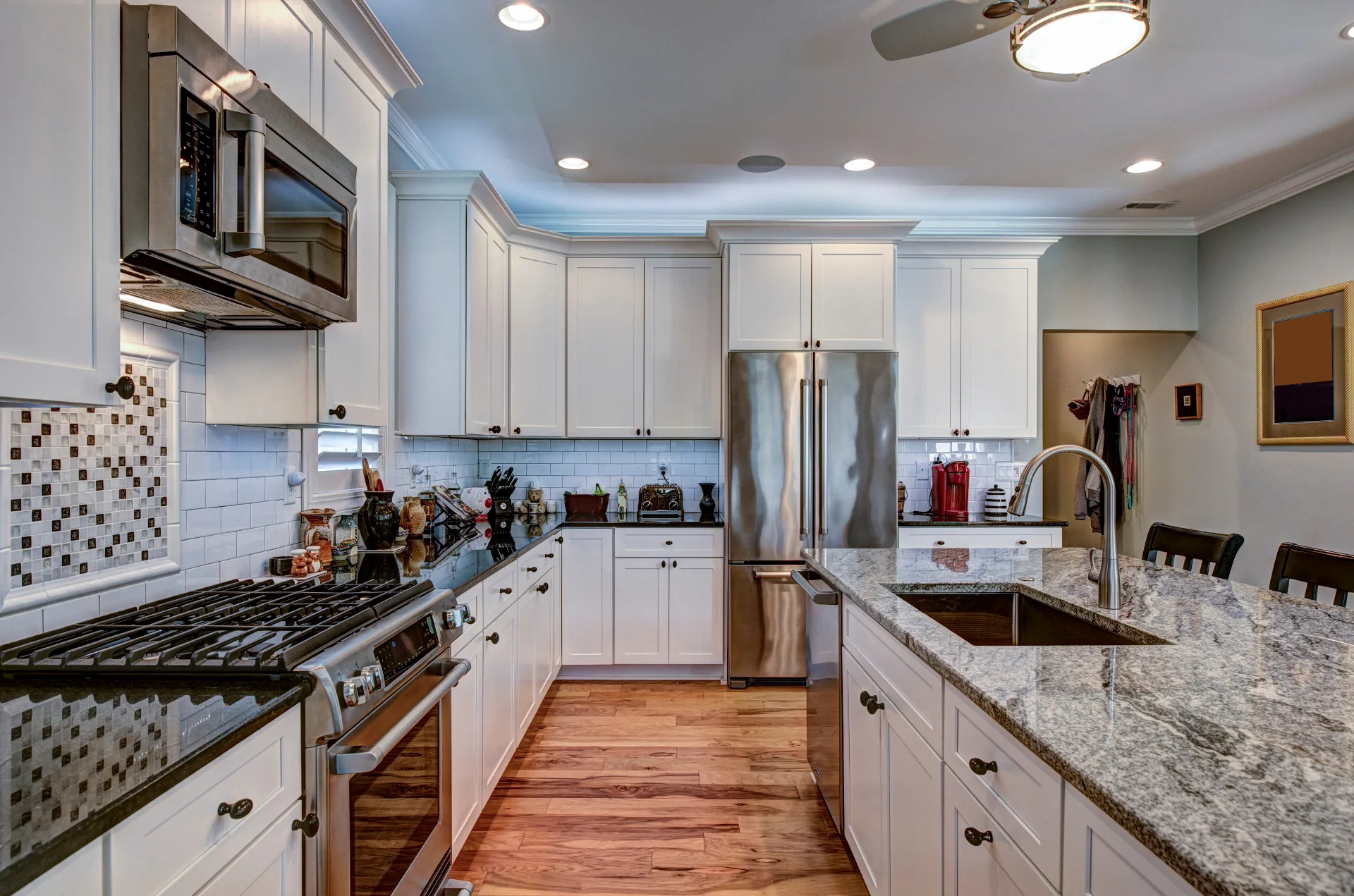Luxury Kitchen with Granite Island - White shaker cabinets, granite countertops, and stainless appliances.